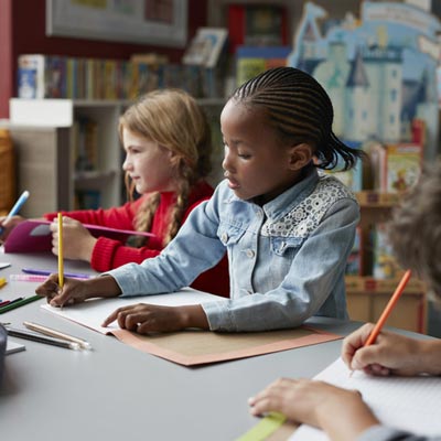 kids drawing at a table in school